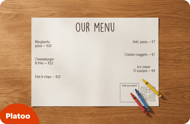 Mantel individual de papel con la carta impresa, con pizza, hamburguesas y platos infantiles, un recuadro «¡Dibuja tu pizza!», un laberinto y tres ceras de colores sobre una mesa de madera