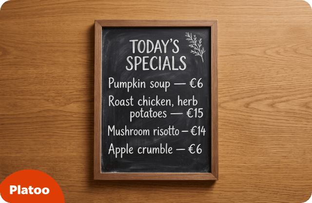 Pizarra con marco de madera con las sugerencias del día y sus precios escritos a tiza: crema de calabaza, pollo asado, risotto de setas y crumble de manzana