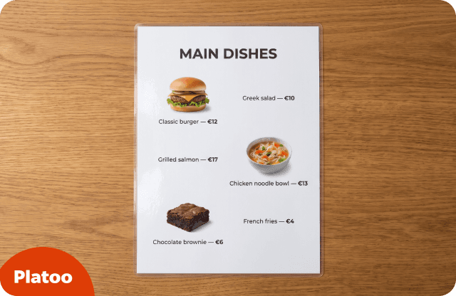 Carta impresa y plastificada de platos principales con pequeñas fotos de una hamburguesa, un bol de sopa de pollo con fideos y un brownie de chocolate junto a los nombres y los precios
