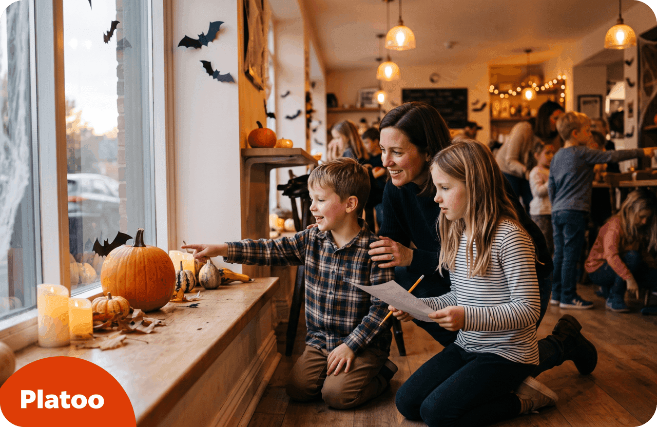 Kinder mit einem gedruckten Hinweisbogen suchen an einem Fenster im Café nach einer versteckten Papierfledermaus